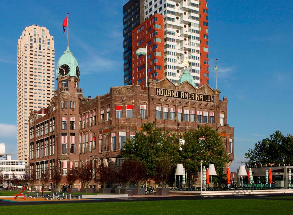 Hotel New York in Rotterdam, the former Holland America Line headquarters, with its green clock tower and waterfront terrace below the Wilhelminapier high-rises