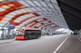 R-NET bus at Amsterdam Centraal station bus terminal under the curved architectural roof, connecting IJmuiden cruise port to Amsterdam city centre