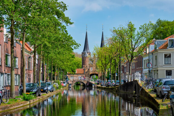 Picturesque canal in Delft city centre with the historic Oostpoort gate, Netherlands