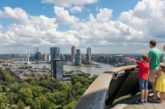 Family with two children pointing at the Rotterdam skyline and Erasmus Bridge from the Euromast observation tower