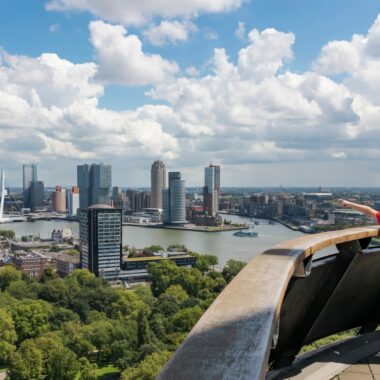 Family with two children pointing at the Rotterdam skyline and Erasmus Bridge from the Euromast observation tower