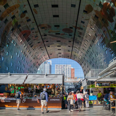 Inside the Rotterdam Markthal covered food market, with its famous arched ceiling artwork and market stalls