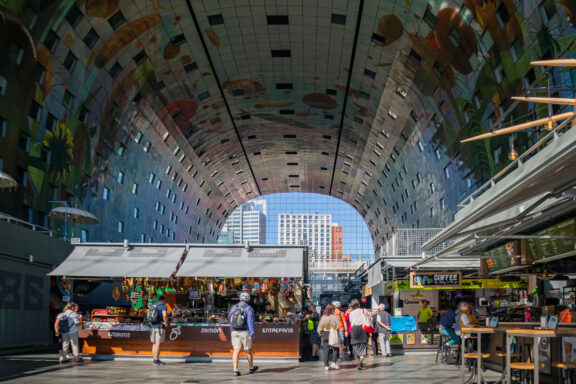 Inside the Rotterdam Markthal covered food market, with its famous arched ceiling artwork and market stalls