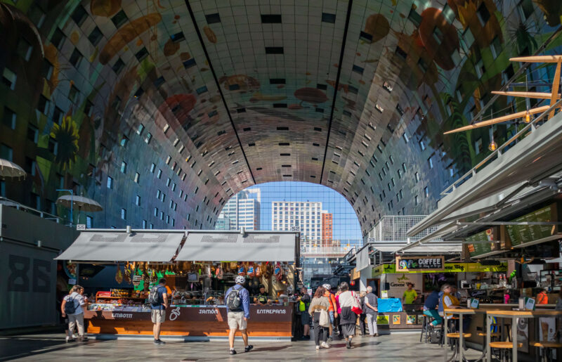 Inside the Rotterdam Markthal covered food market, with its famous arched ceiling artwork and market stalls