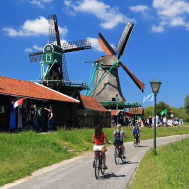 Cyclists visiting the historic windmills of Zaanse Schans, Netherlands