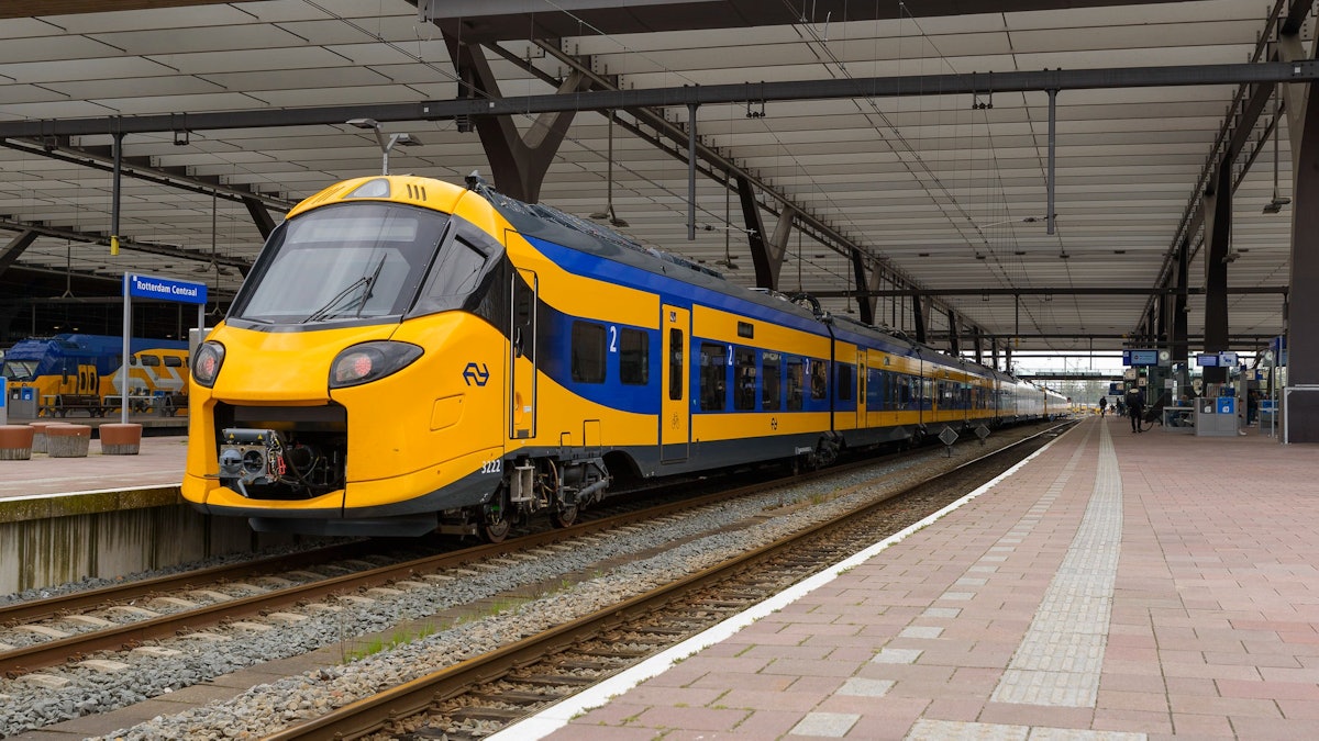 A yellow and blue NS Intercity train waiting at a Dutch station platform