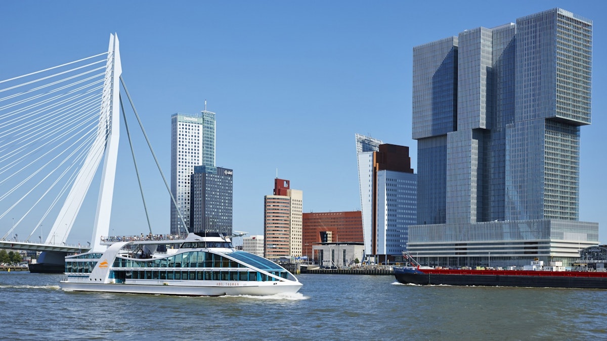 A Spido harbour cruise boat on the Maas in front of the Erasmus Bridge and the Wilhelminapier towers